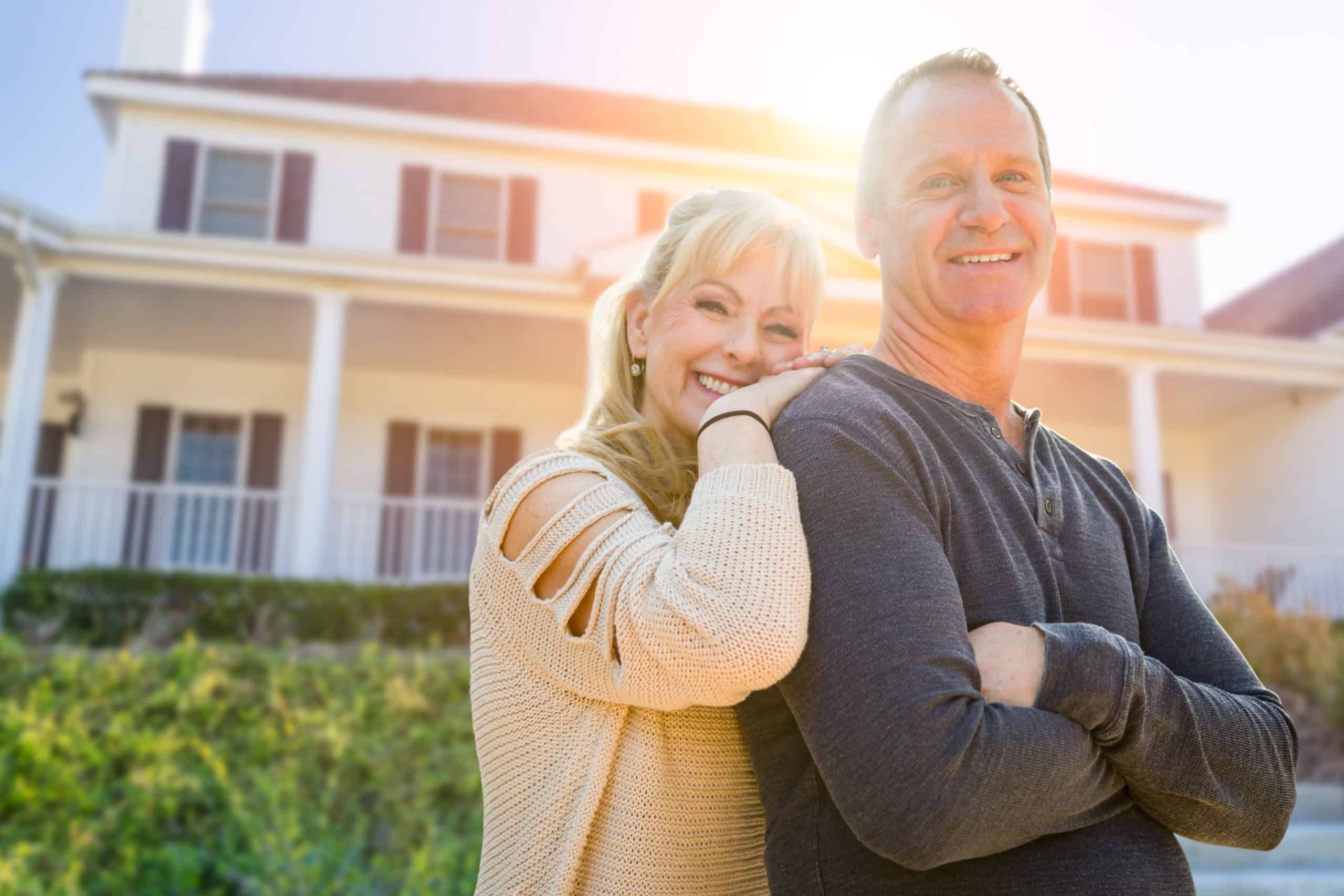 Middle-aged Couple In Front Of Their House.