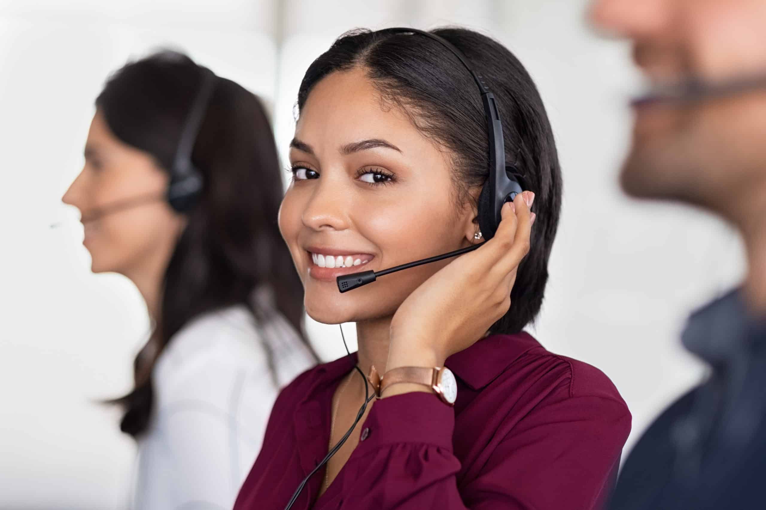 Smiling beautiful woman working in call center as telemarketing operator