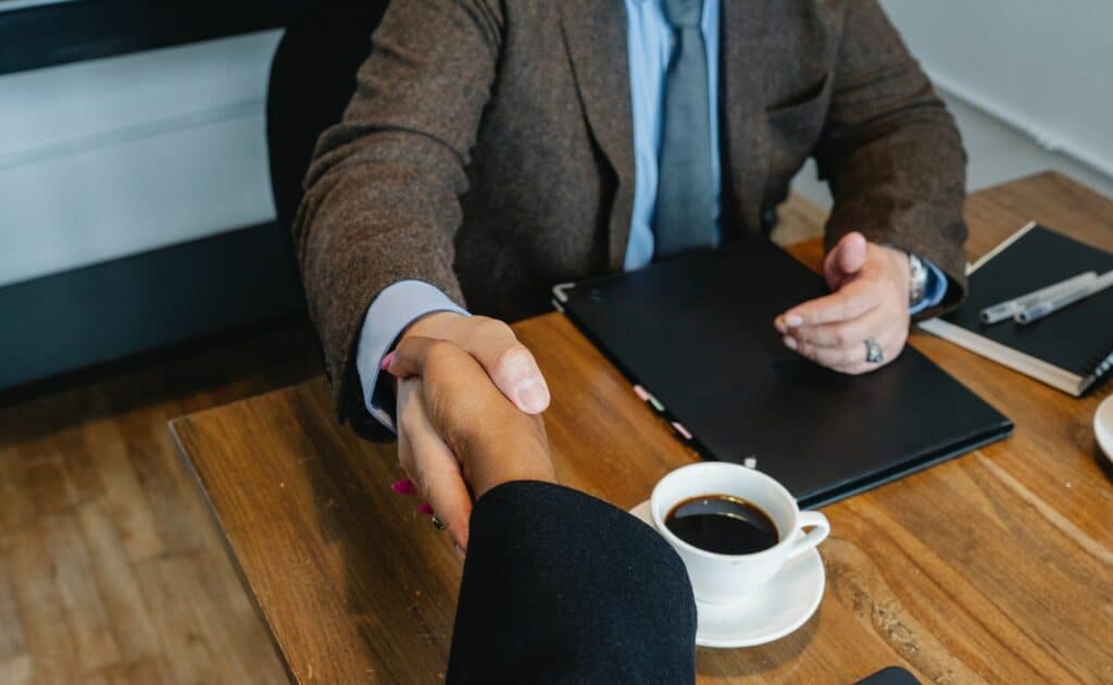 Two individuals shaking hands after making deal