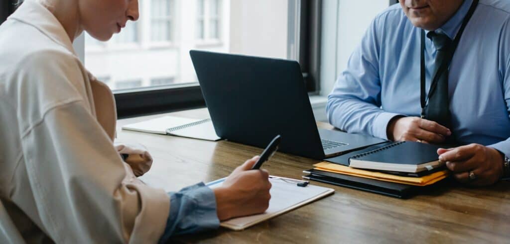 Cropped Business Partners Signing Papers in Office